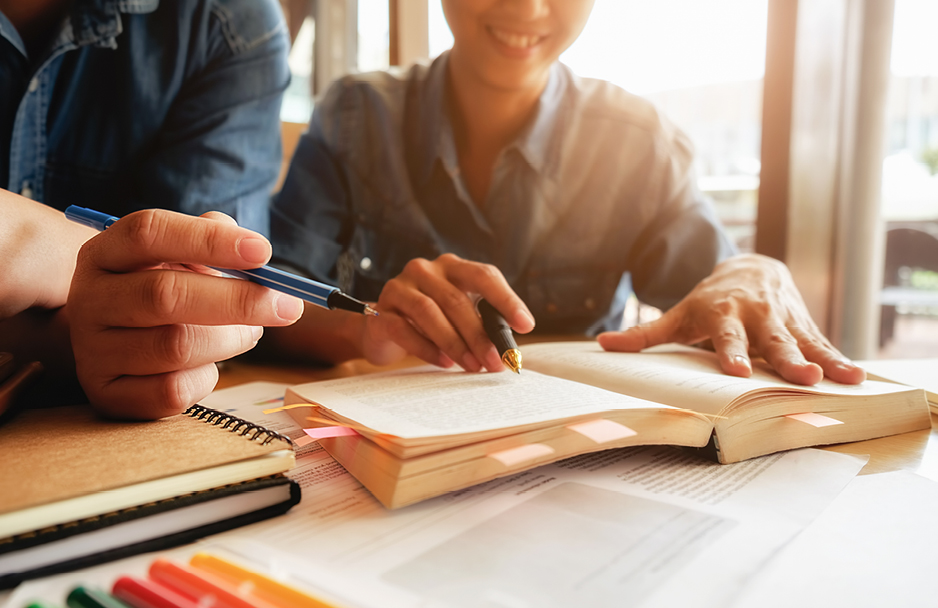 Two people reading a book together