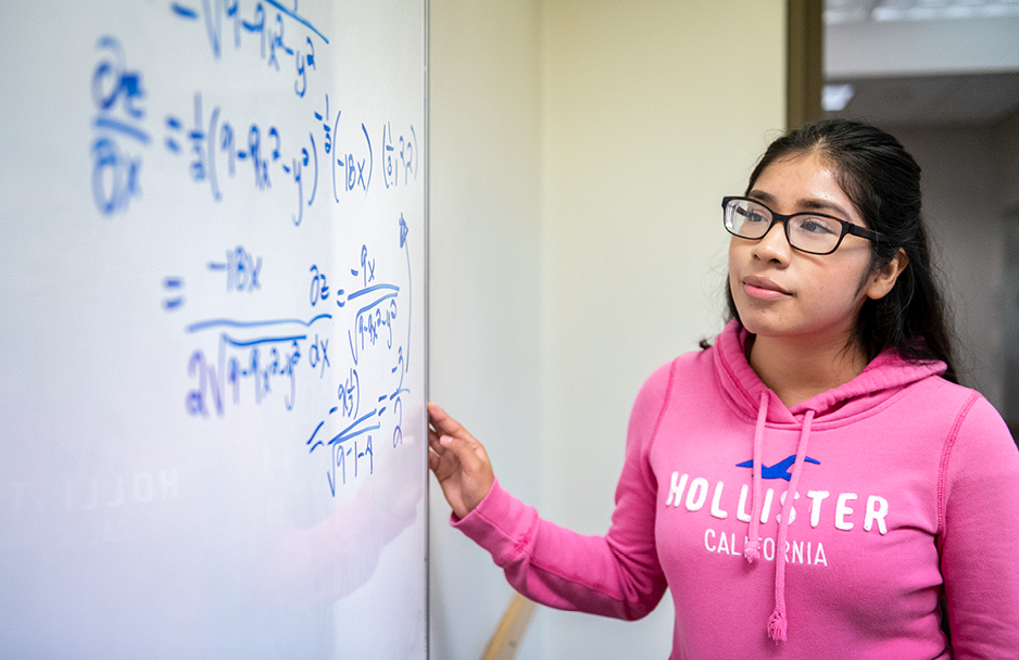 Student working on Math problems on a whiteboard