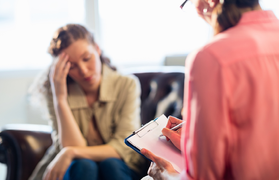 Woman taking notes while talking to another woman