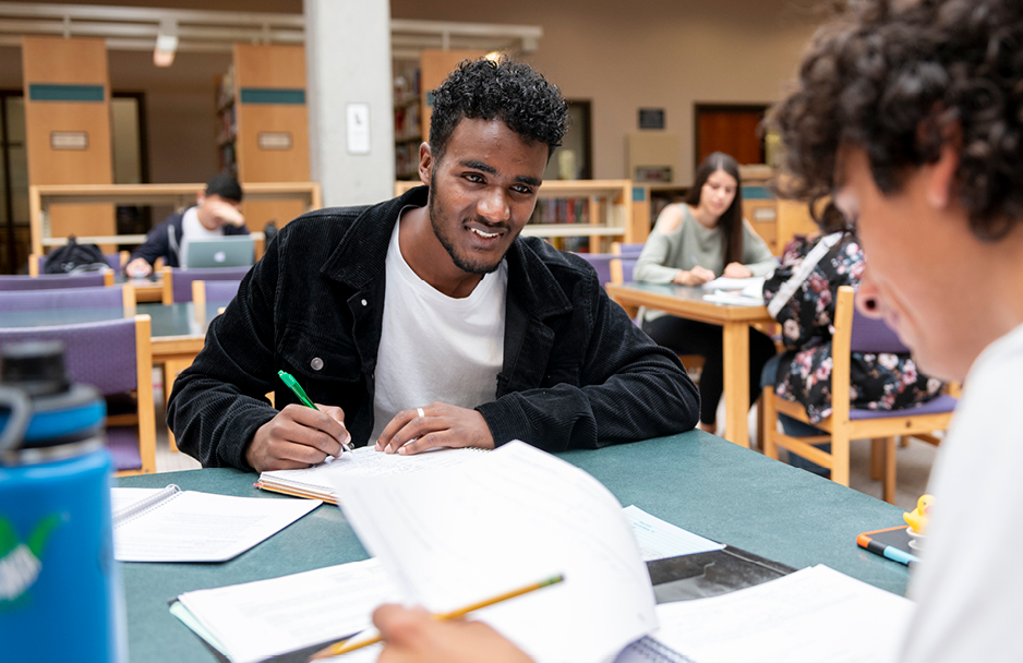 Student speaking to another student in the library.