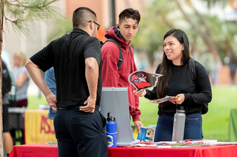 Student talking to university representative at a fair