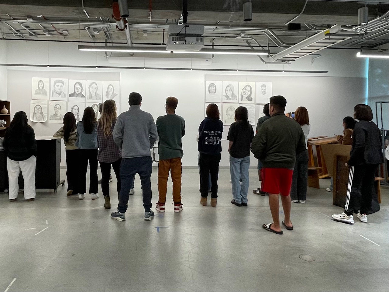 Students looking at drawings hanging on a wall