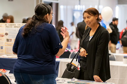 Woman speaks to employer at job fair.