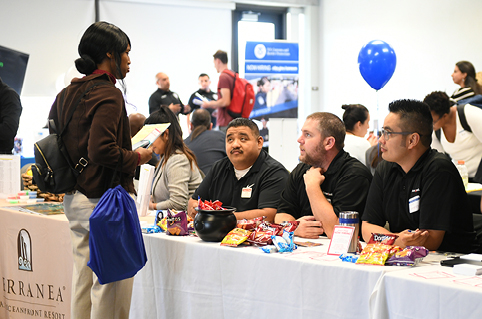 Student talking to employers at job fair.