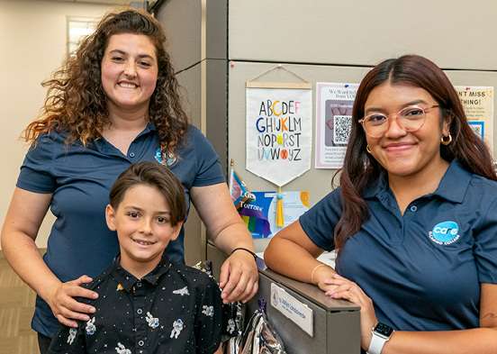 CARE student, her child and staff member smiling.