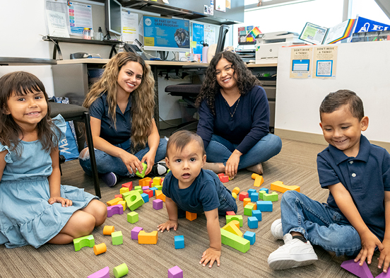 CARE student and her children playing with colorful toy blocks.