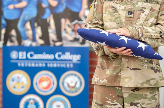 Person holds folded USA flag. 